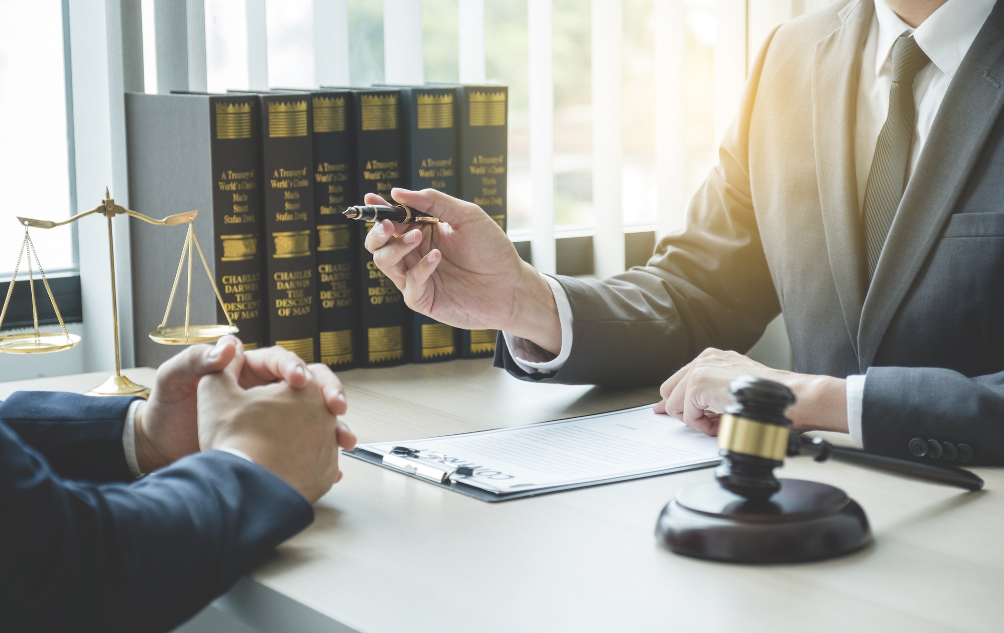 Lawyer hand holding pen and providing legal consult business dispute to the man