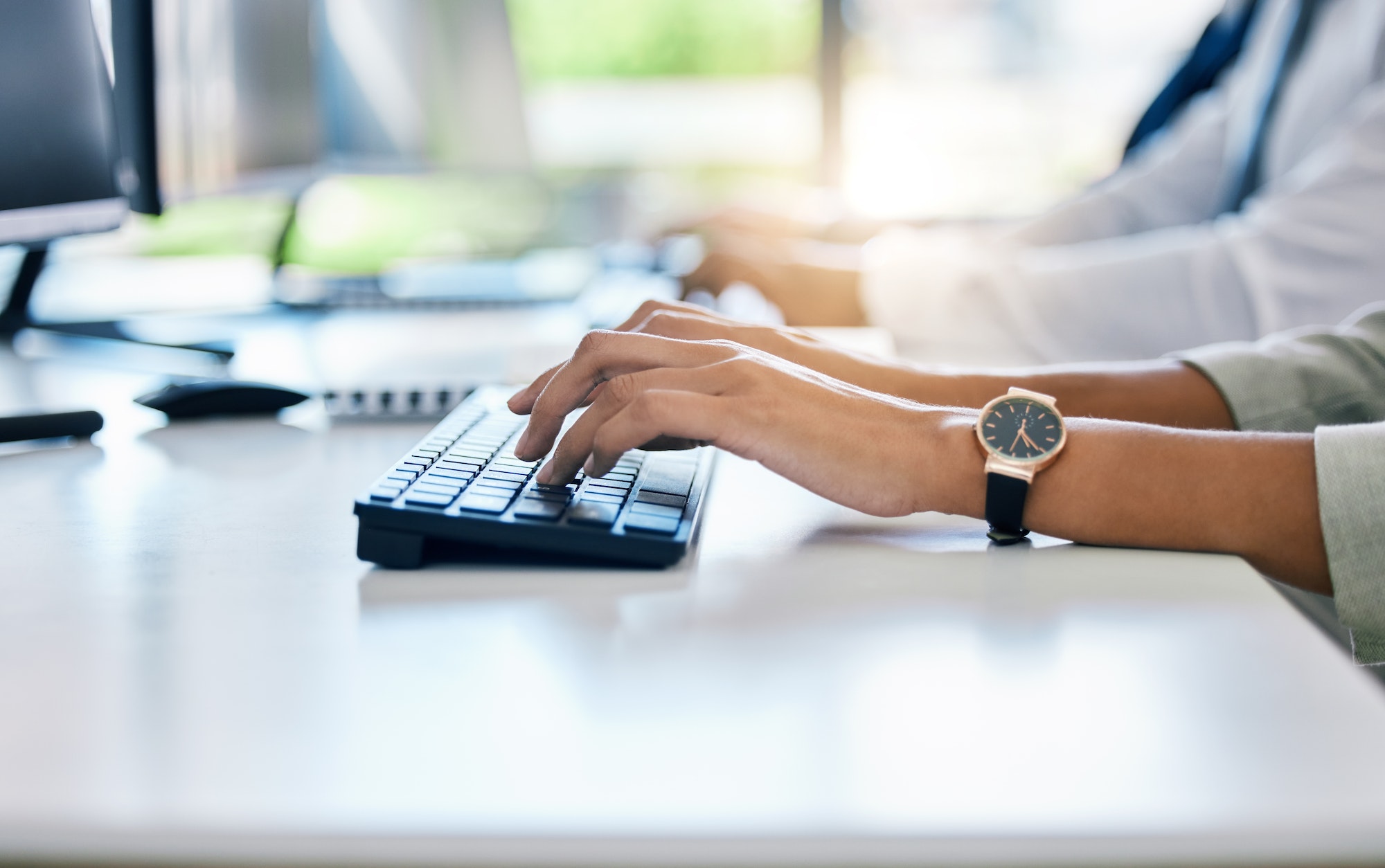 Hands, keyboard and typing with a business woman working on a computer at her desk in the office. F