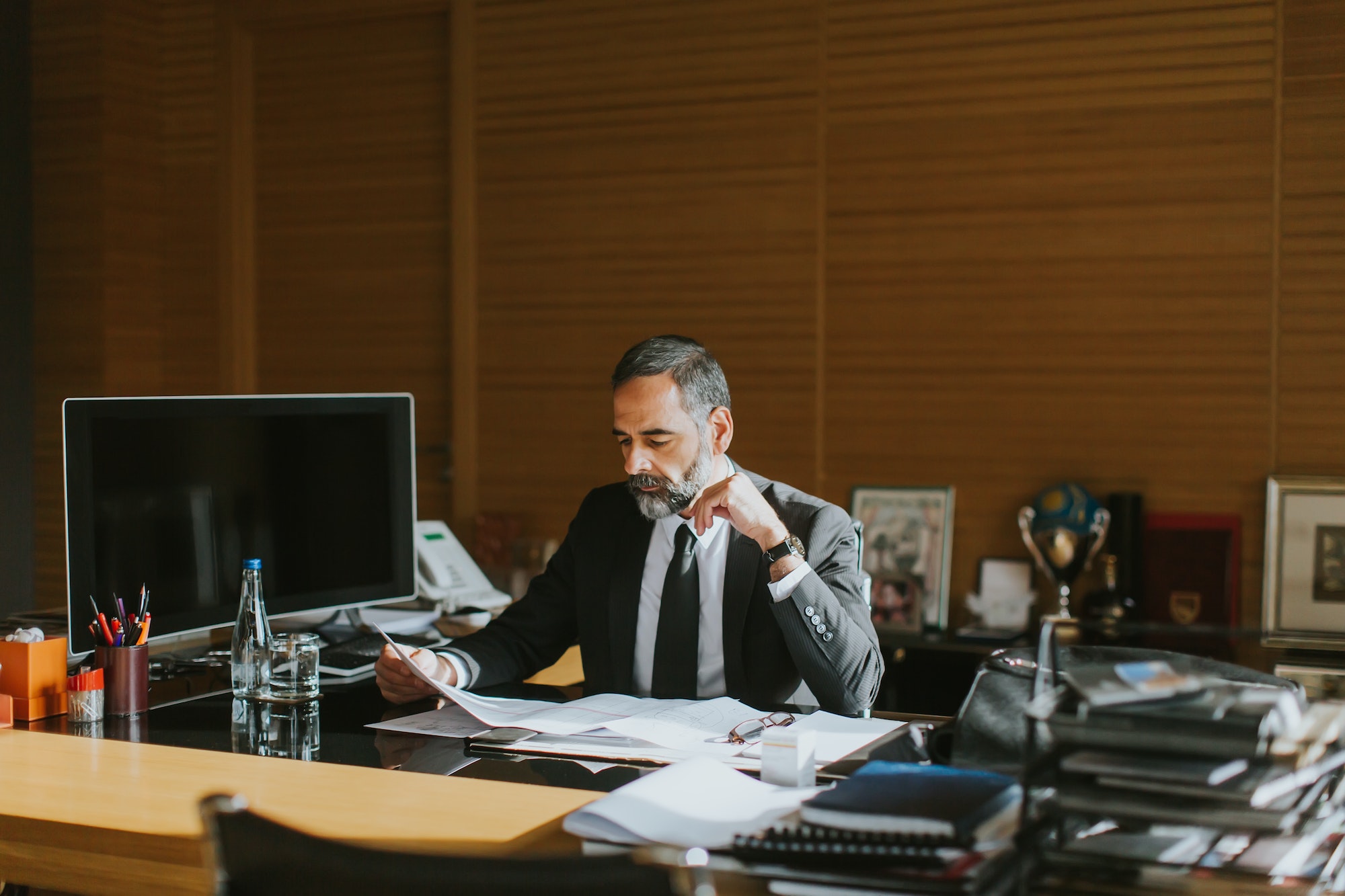 Senior businessman working on laptop in modern office